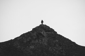 Silhouette of a man on top of a rocky mountain