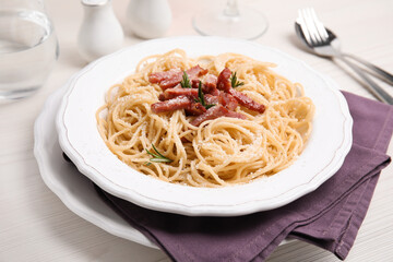 Delicious Carbonara pasta served on white wooden table