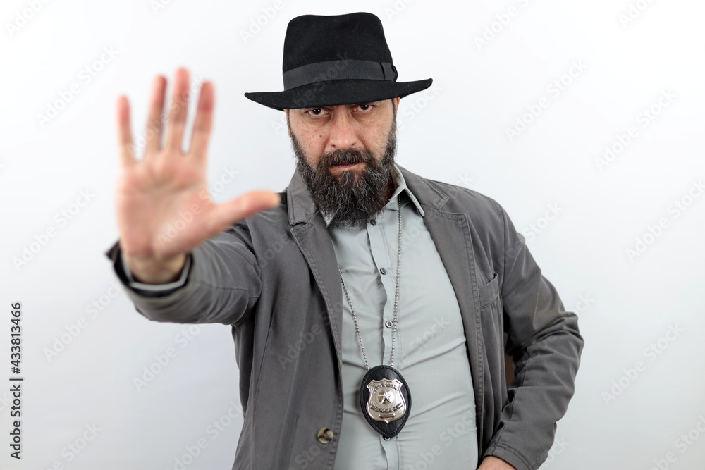 Wall mural Bearded detective with serious face showing making stop sign with hand. Crime concept.