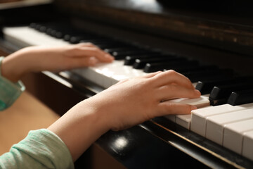 Obraz premium Little child playing piano, closeup. Music lesson