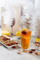 Christmas tea with spices on a white table.