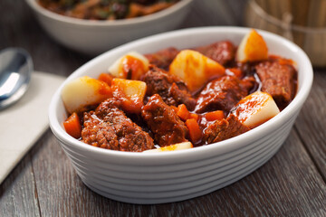 Hot stew with mushrooms and potatoes on a plate.