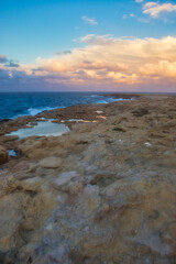 Coastline on a rocky beach in Qawra, Malta on a fall evemomg at sunset.