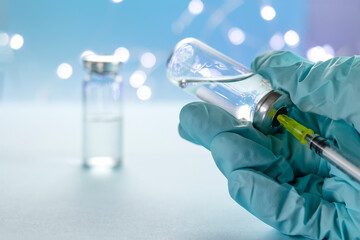 doctor, nurse, scientist, researcher hand in blue gloves holding flu, measles, coronavirus vaccine disease preparing for human clinical trials vaccination shot, medicine and drug concept.