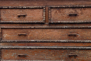 old cracked wooden chest of drawers. background with brown cracks on a wooden chest of drawers with...