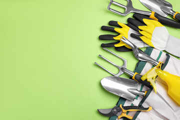 Flat lay composition with gardening tools on green background, space for text