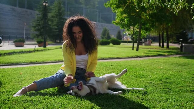 Happy girl with playful husky dog outdoors