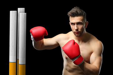 Sporty male boxer kicking cigarette on dark background