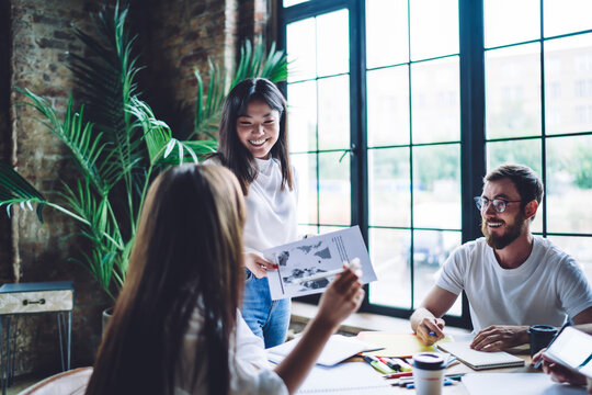 Cheerful multiethnic colleagues brainstorming together in workspace