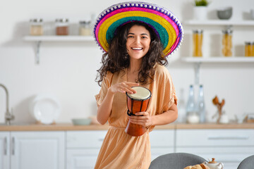 Young woman in sombrero hat with tam-tam at home