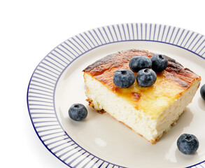 Plate with piece of cottage cheese casserole on white background