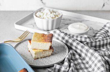 Plate with pieces of cottage cheese casserole on table