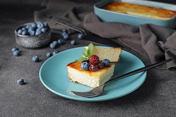 Plate with pieces of cottage cheese casserole on grunge background
