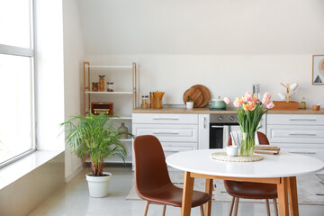 Bouquet of beautiful tulip flowers on table in kitchen