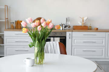 Bouquet of beautiful tulip flowers on table in kitchen