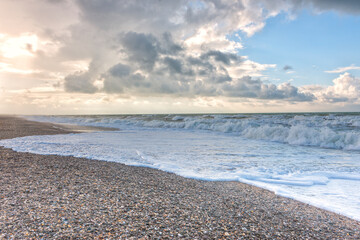 The landscape of the sea coast with the waves rushing on it