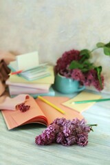 Blank notebook for drawing, books, pencils, bouquet of flowers on the table, learning concept, back to school