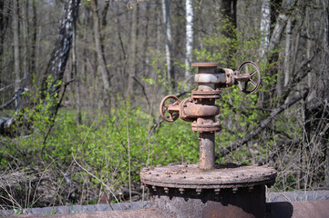 A hydrant on an industrial water supply pipeline on the background of a spring forest. Background