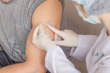 A nurse puts a band-aid on the patient's arm after the procedure.