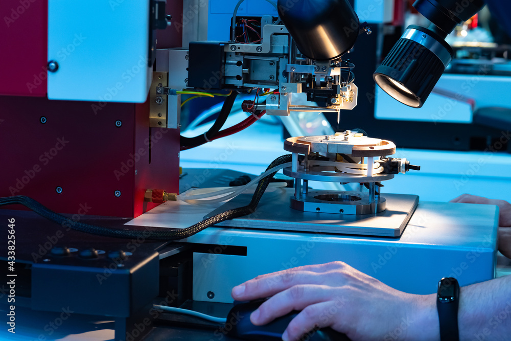 Poster study of test sample of transistor microchip under microscope. man hand uses microscope to work with