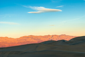 Fototapeta na wymiar Desert landscape with dunes and mountains at sunrise.