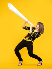 Woman is holding a loudspeaker made of paper. Concept - she is trying to shout to someone. Woman...
