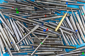Many dental drills and burs as a background, texture, pattern. - obrazy, fototapety, plakaty