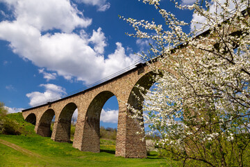 Fototapeta premium Old railway stone viaduct in the spring in sunny day.