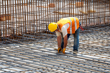 Construction worker installing floor slab reinforcement bars