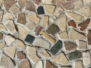 Background of a decorative wall made with flat stones of different shapes and colors