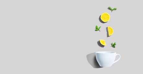 Fresh yellow lemons with tea cup overhead view