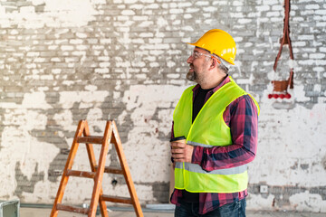 construction worker analyzing plans during coffee break in a workshop