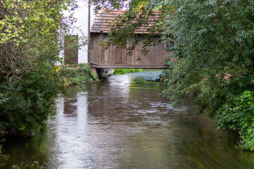 Fototapeta na wymiar The river gera flows under a wooden building in Erfurt