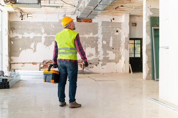 adult construction worker working on a wall inside the new house