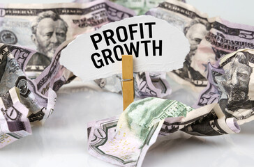 There are dollars on the table and there is a clothespin with paper on which it is written - PROFIT GROWTH