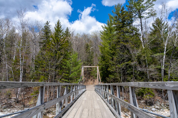 Fototapeta na wymiar Wooden bridge over the pemigewasset river. Lincoln Woods Trail, White Mountains, New Hampshire,