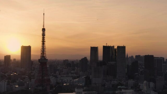 Video of a cityscape depicting the Tokyo tower and Roppongi Hills skyscrapers at sunset in the Daimon district of Tokyo city.