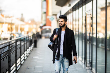 Portrait of young man with backpack on city street.