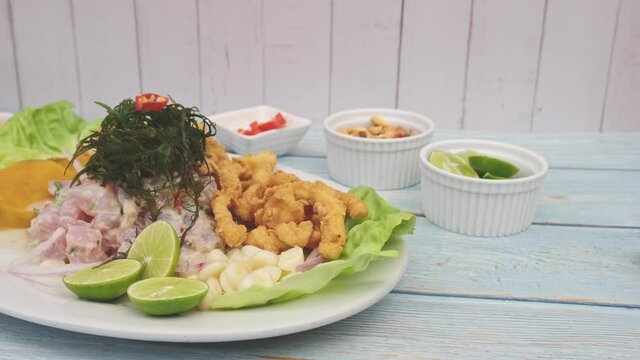 Traditional Peruvian ceviche accompanied by fish, corn pancake, sweet potato, canchita and plenty of spicy juice. Ceviche y chicharron de pescado
