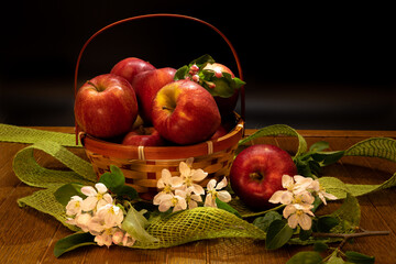 Fresh apples with apples blossoms on a dramatic dark wood background. Naturmort made from pears in a bowl.