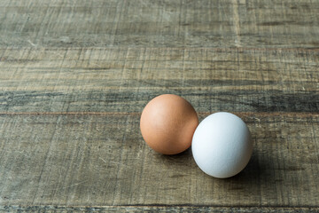 white and cream eggs isolated on the wooden table in sunlight