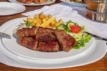Balkan cuisine. Cevapi - grilled dish of minced meat - with vegetables