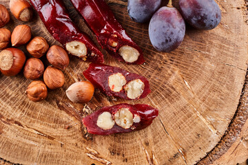 Churchkhela, national Georgian dessert made from grape juice and hazelnuts, composition on a wooden table