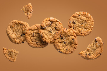 Macaroons. Whole biscuits and pieces. The liver seems to be floating in the air. Light brown background and beige cookies. There are no people in the photo. Abstraction. Texture. Wallpaper.