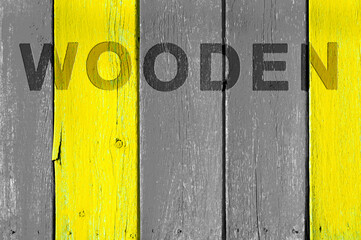 Wooden background from yellow-gray planks with cracked paint and a dent in wooden inscription.
