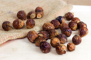 Brown dry soap nuts (Soapberries, Sapindus Mukorossi) for organic laundry and gentle natural skin care on light background. - 433842254