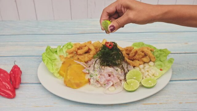 Traditional Peruvian ceviche accompanied by fish, corn pancake, sweet potato, canchita and plenty of spicy juice. Ceviche y chicharron de pescado
