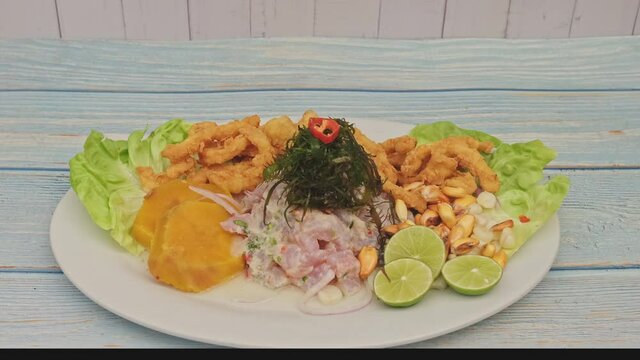 Traditional Peruvian ceviche accompanied by fish, corn pancake, sweet potato, canchita and plenty of spicy juice. Ceviche y chicharron de pescado
