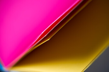 colourful blank book with pages partly opened to magenta/pink and yellow paper