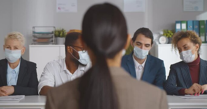 Executives wearing protective mask interviewing woman applicant